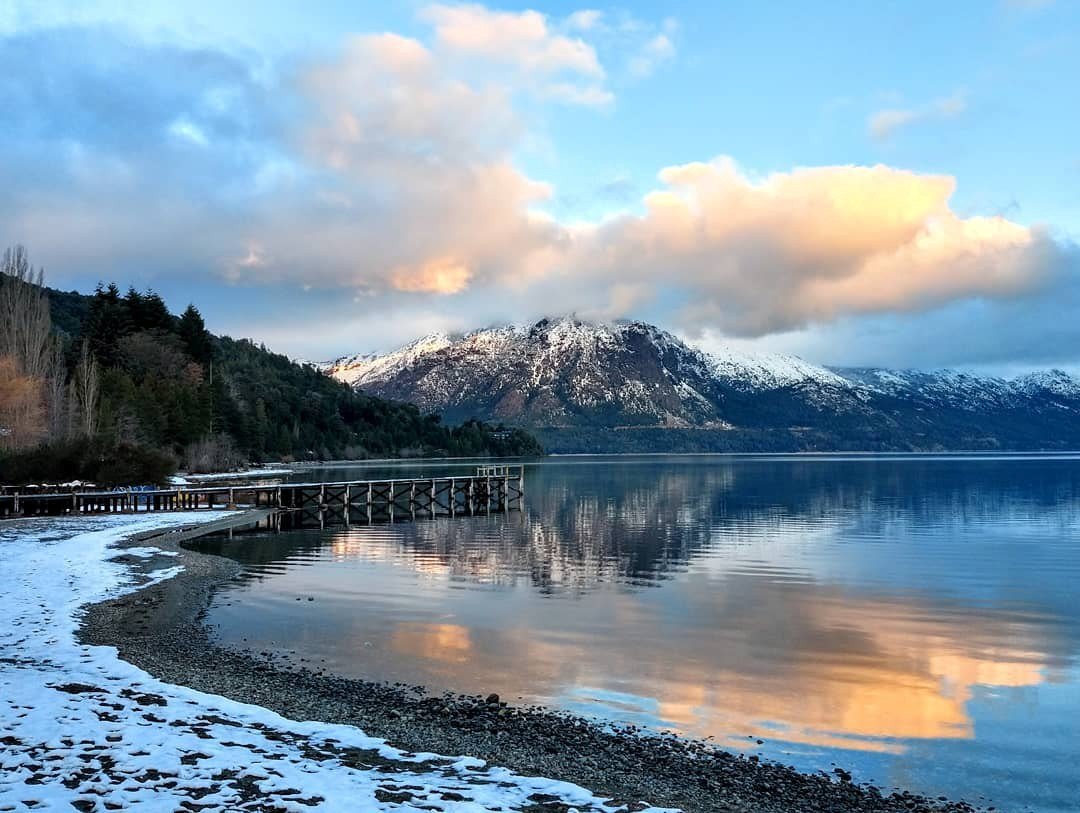 Lago patagónico con montañas nevadas al atardecer